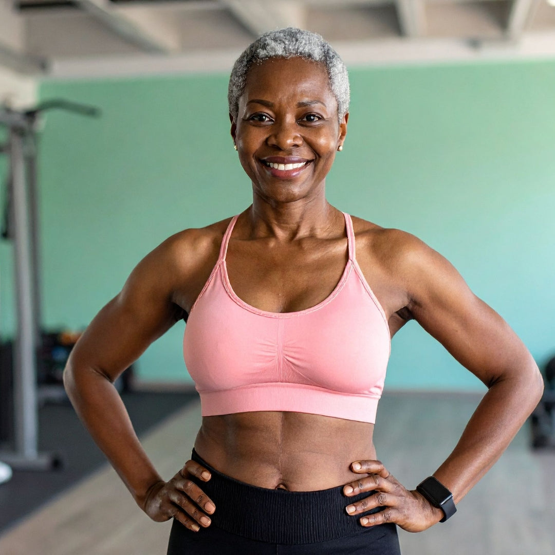 Woman in a pink sports bra and black leggings standing in a gym.